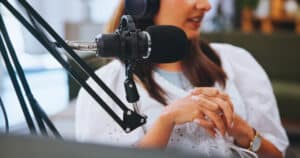 Hands, woman and mic for podcast, talk show and conversation with broadcast, radio or closeup. Person, host or influencer with equipment for live streaming, tech for political news channel or explain